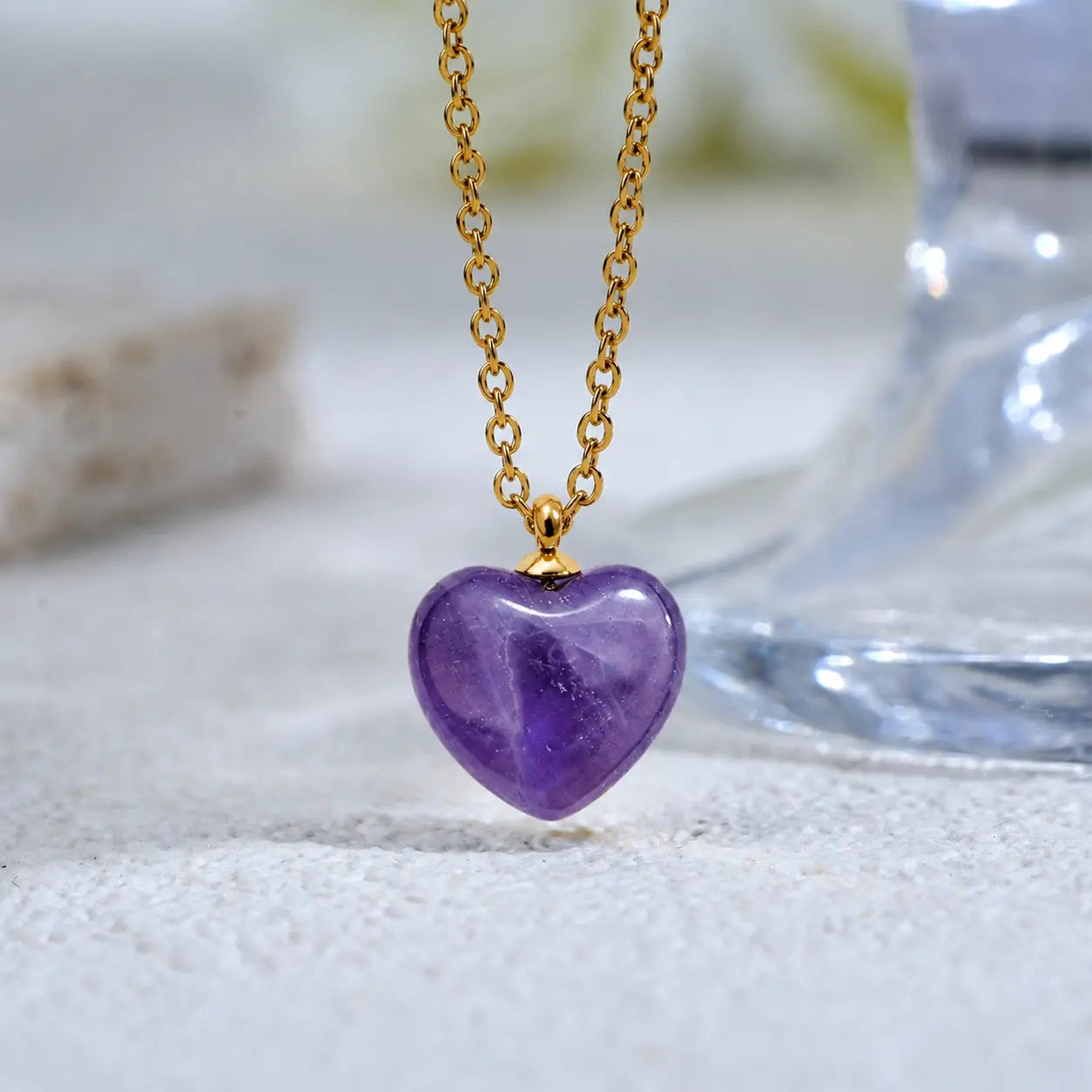 Macro close up of the flawless simulated amethyst stone texture and 18k gold chain of MEHRZEB necklace.