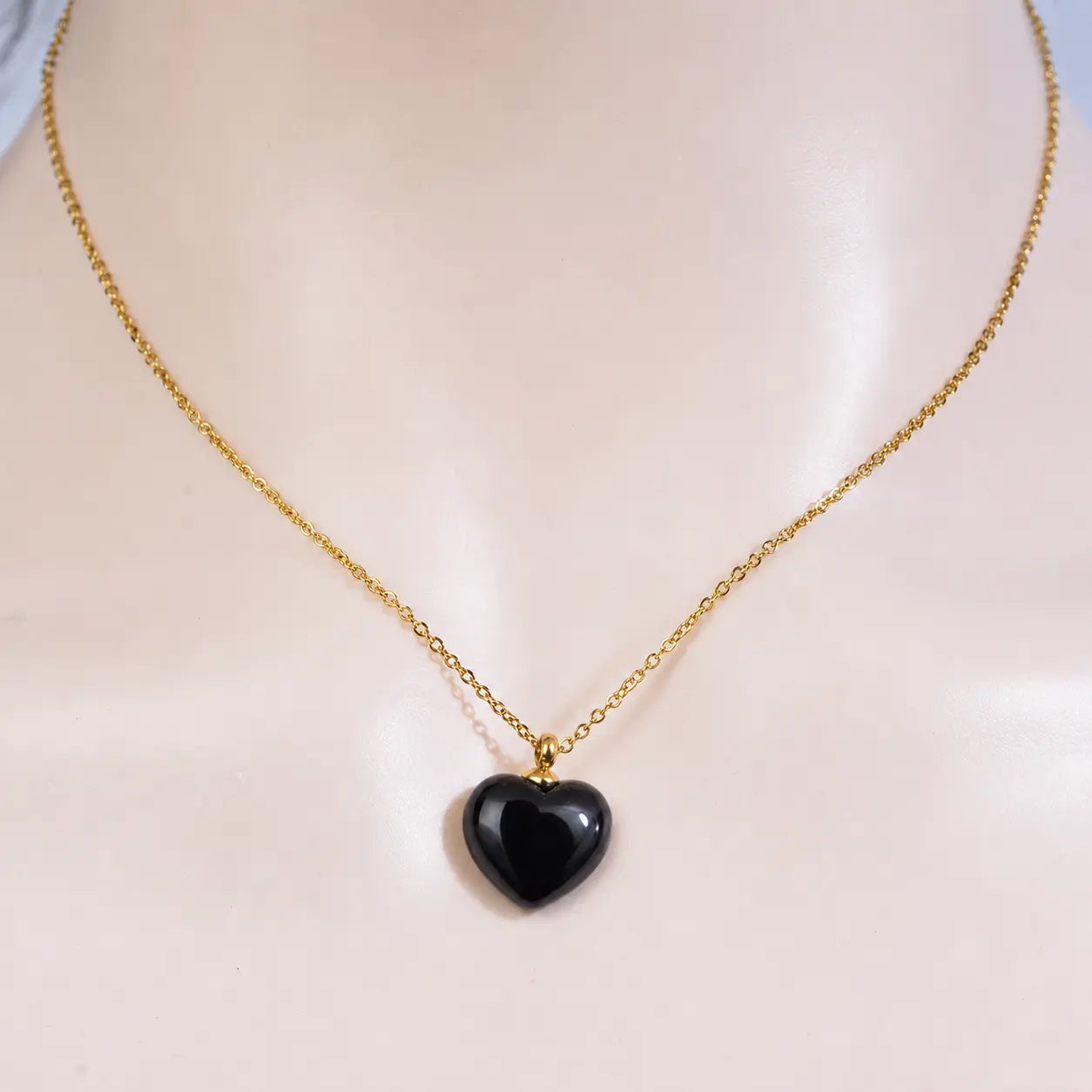Front view of a model wearing the minimalist MEHRZEB luxury black heart pendant necklace.