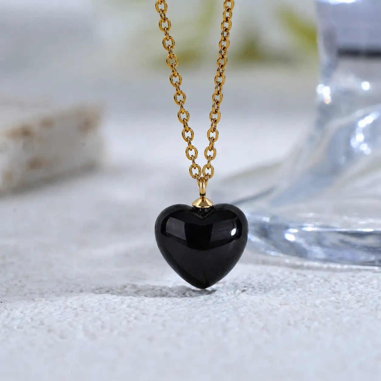 Macro close up of the flawless black heart stone and delicate 18k gold chain of MEHRZEB necklace.