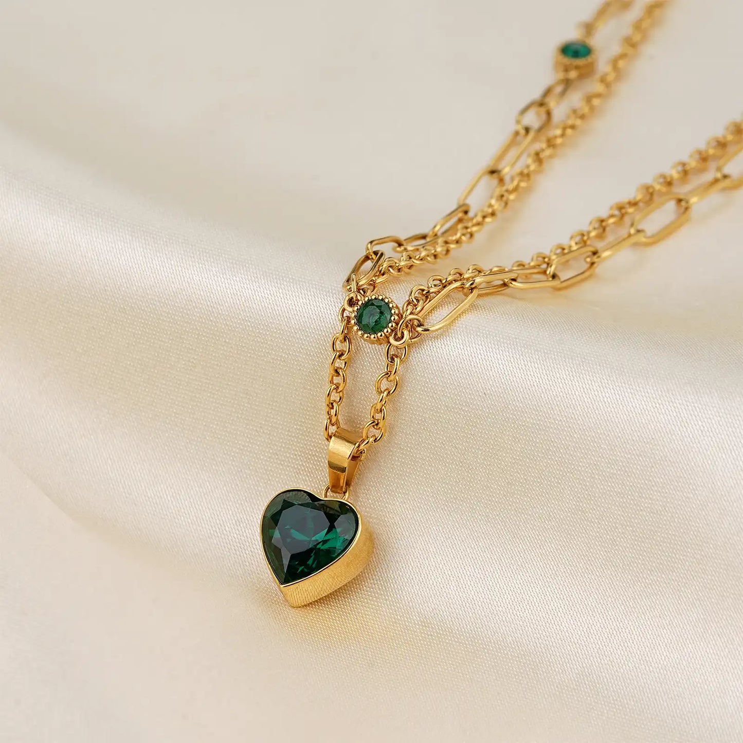 Macro close up of the premium emerald green heart cut zircon stone and 18k gold layered chain by MEHRZEB.