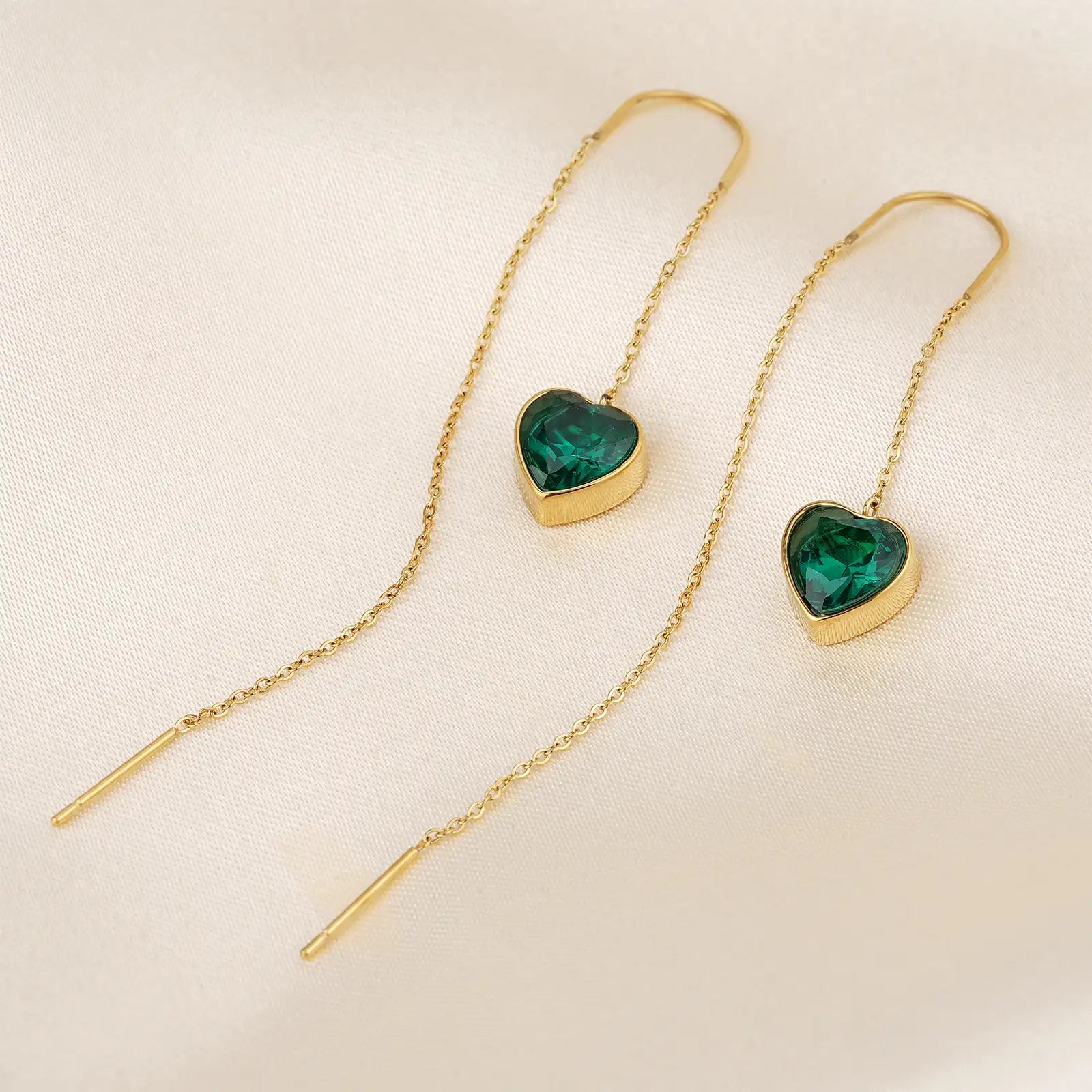 Macro close up of the flawless emerald green heart zircon and delicate 18k gold chain of MEHRZEB threader earrings.