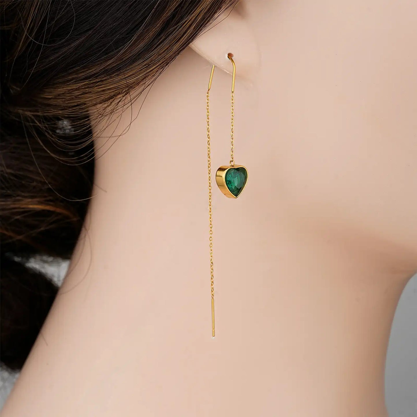 Front view of a model wearing the MEHRZEB luxury emerald heart drop threader earrings.