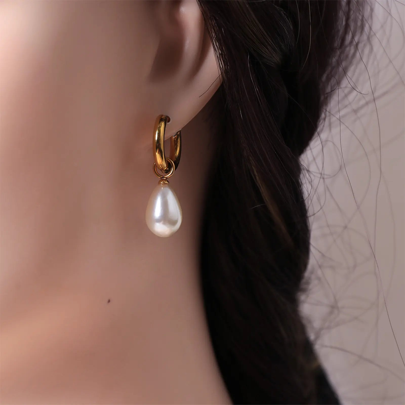 Side profile of a model wearing the MEHRZEB luxury simulated pearl drop hoop earrings.