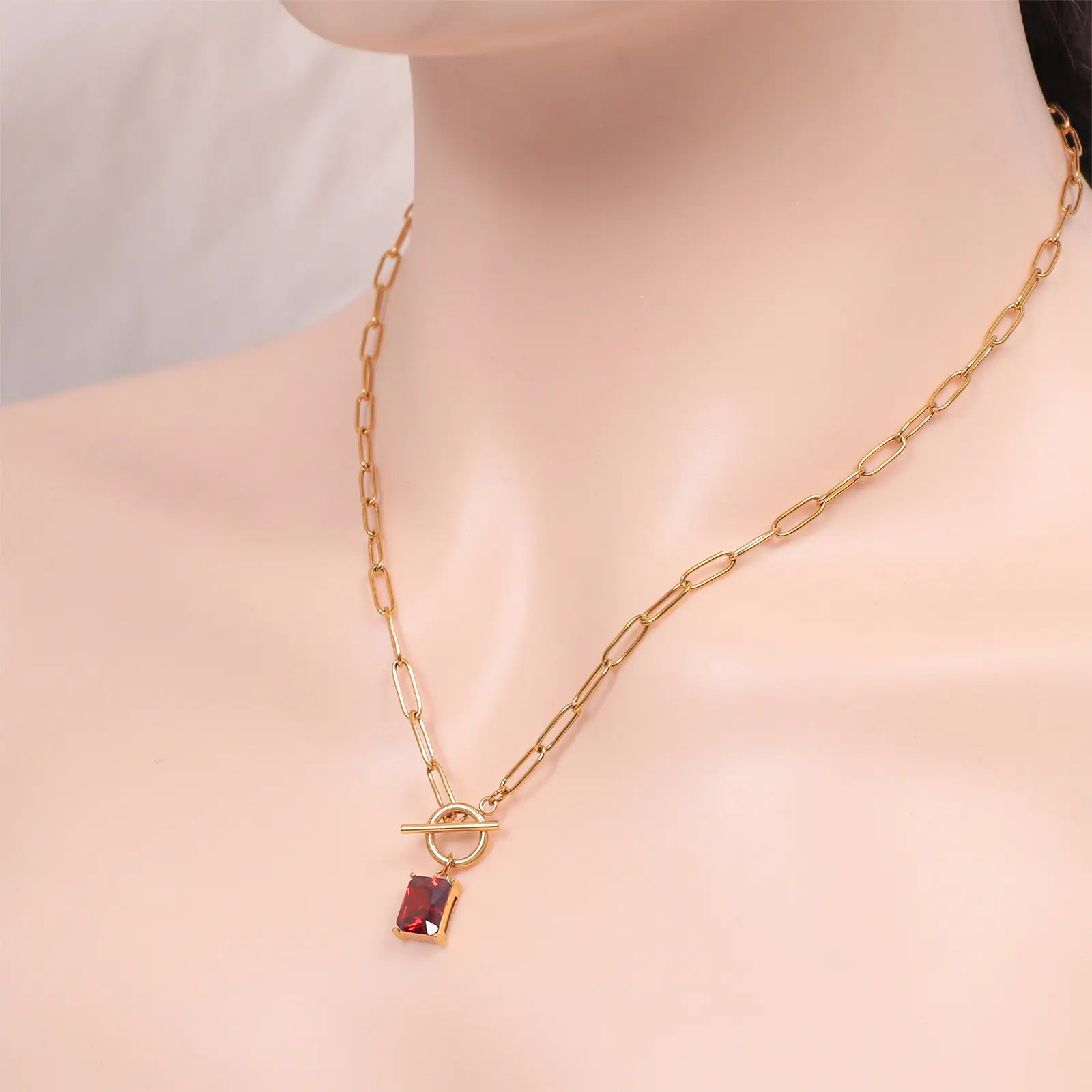 Close up angled view of the MEHRZEB rectangular ruby pendant necklace on a model's neck.