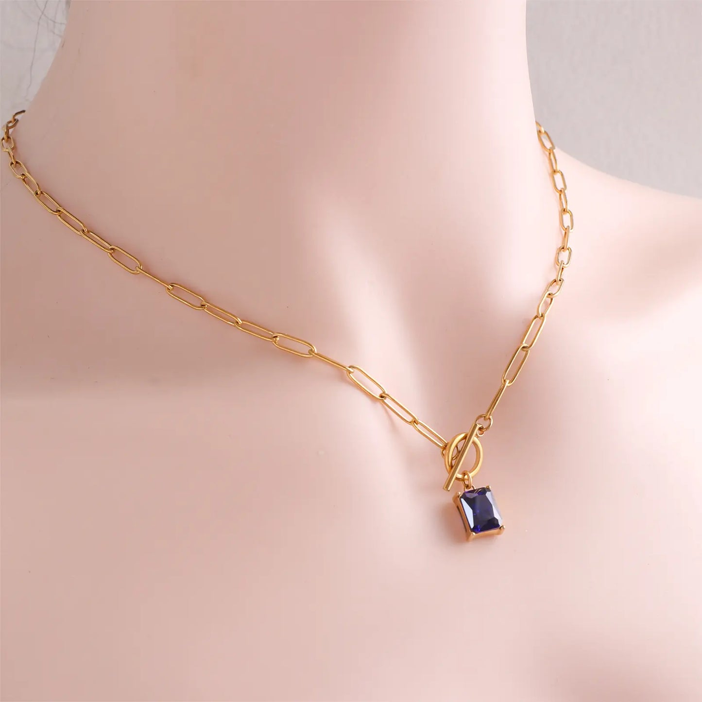 Angled view of the MEHRZEB rectangular sapphire pendant necklace on a model.