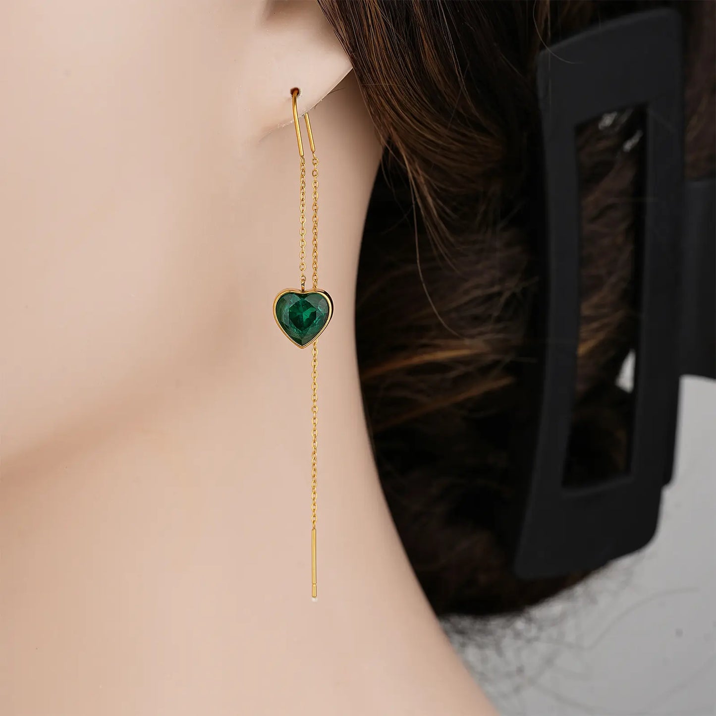 Side profile view showing the elegant drop length of the MEHRZEB emerald heart threader earrings on a model.